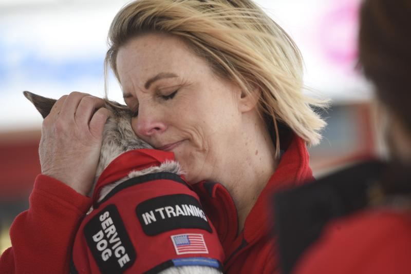 Gold Star mother Karen Vaughn hugs a service dog in training named Vaughn, after her son Aaron Carson Vaughn who died in service. DENY HOWETH PHOTOS